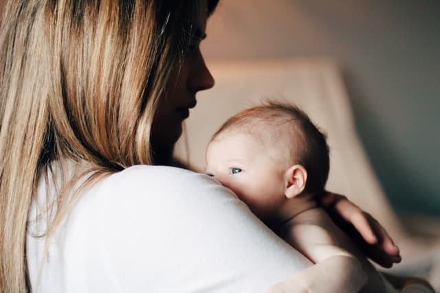 une mère porte son bébé atteins de colique